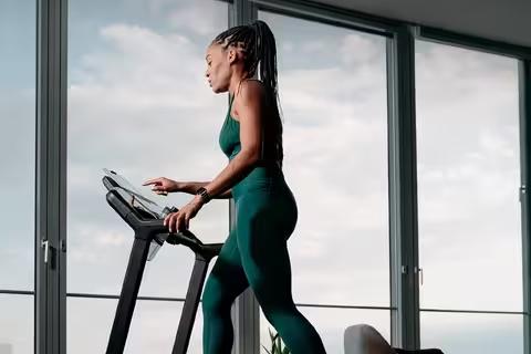 Femme faisant du sport sur un tapis de course.